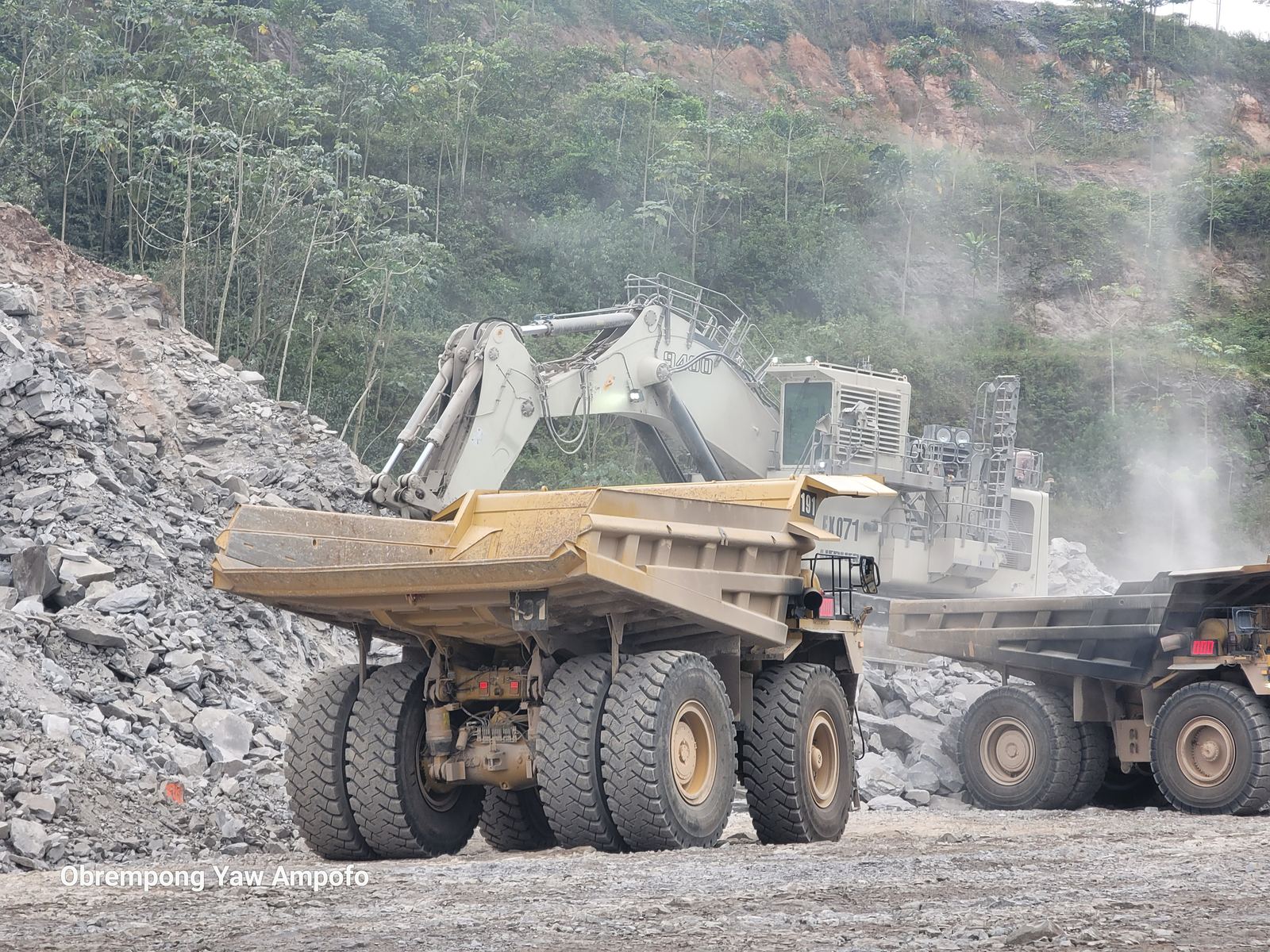 Haul trucks and an excavator loading rock at the Goldfields Damang open-pit mine
