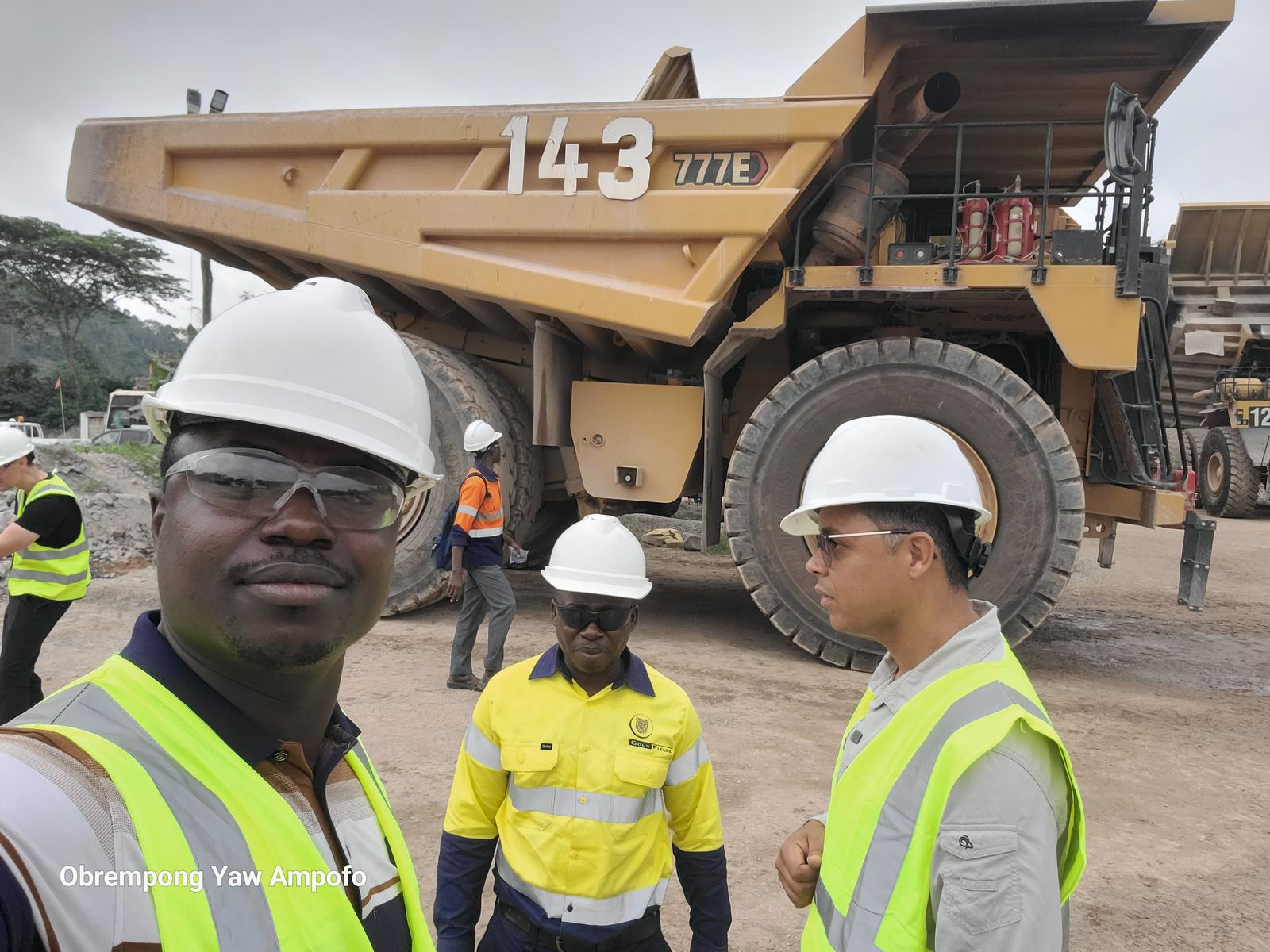 Crew and GRRMC team member in front of a large mining haul truck at Goldfields Damang